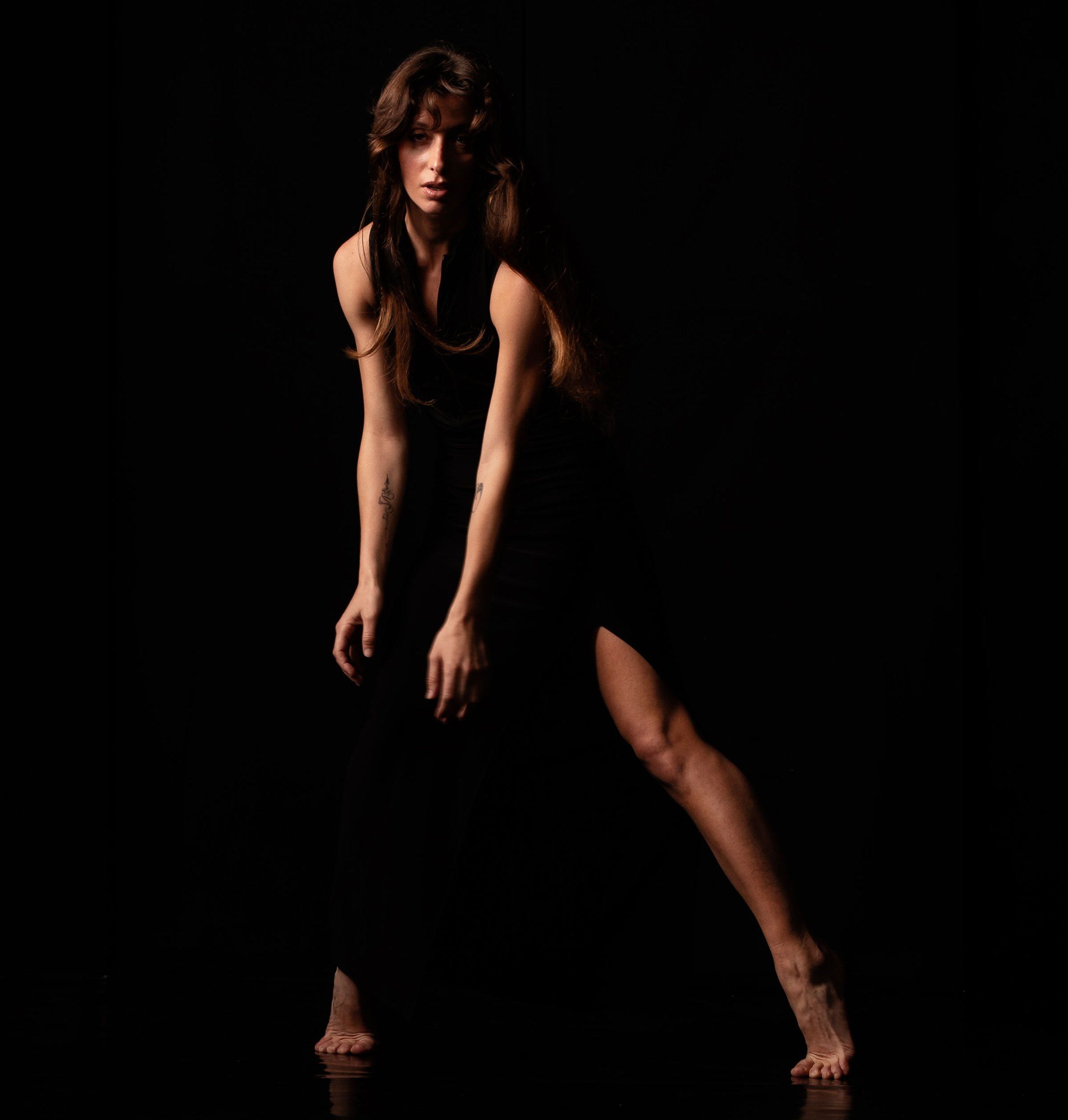 Ballerina in piedi, postura aperta e sguardo diretto