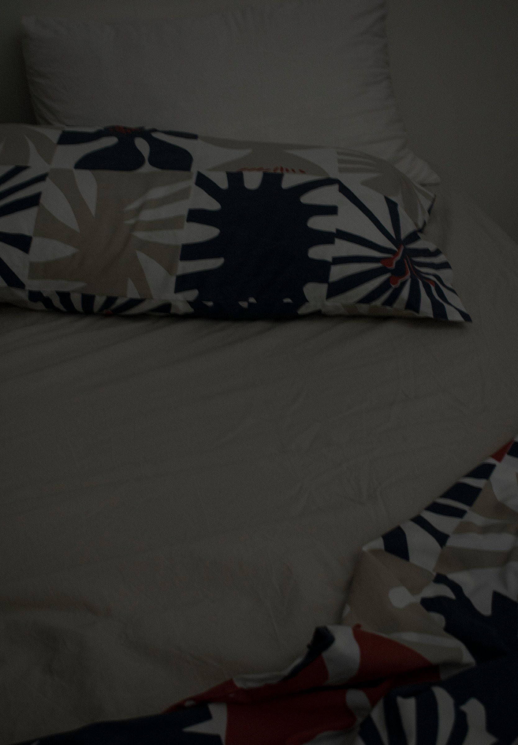 Un letto sfatto, cuscini a fiori