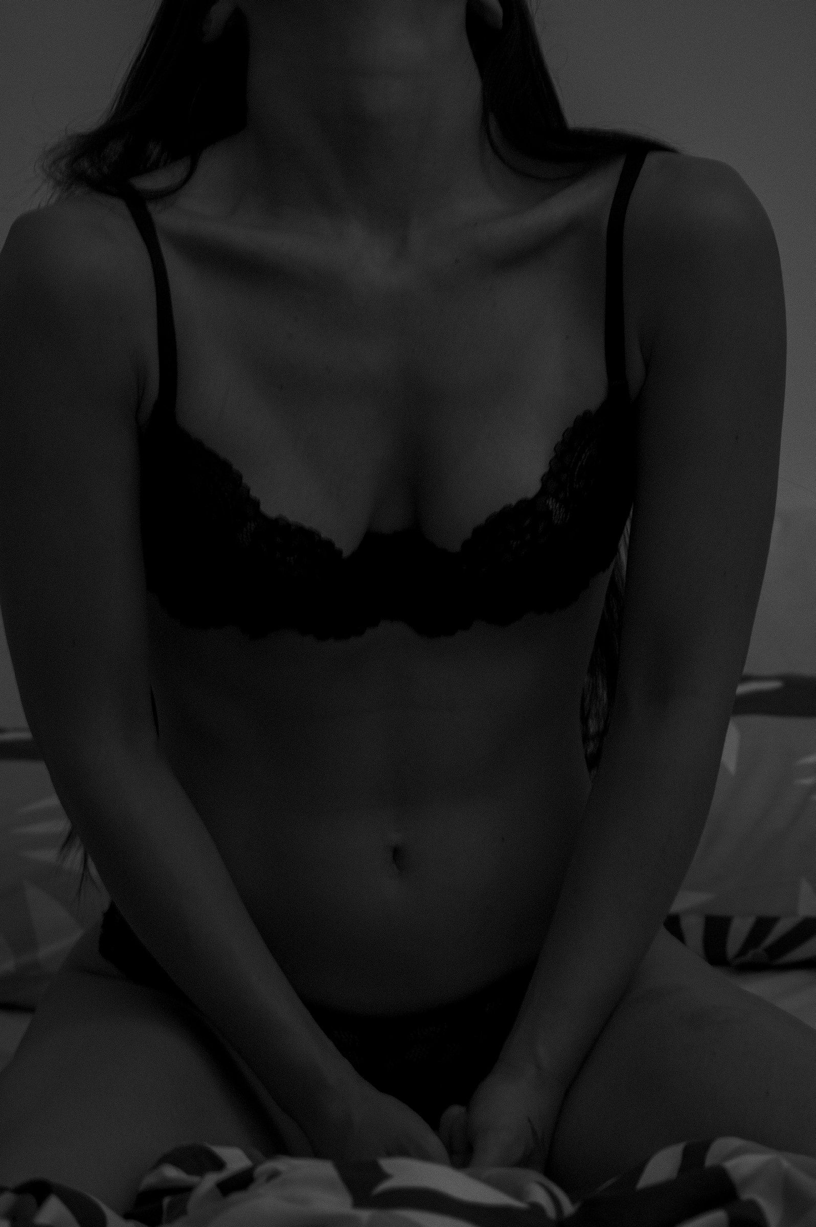 Bianco e nero: donna seduta sul letto in lingerie